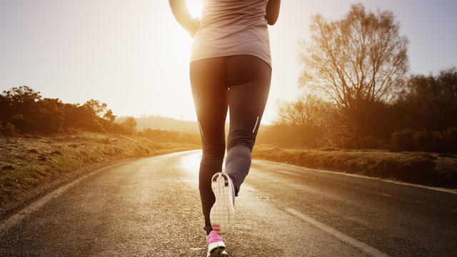 Female runner running along road 